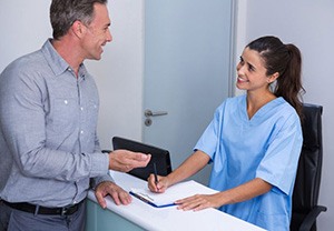 Dental team member helping patient at front desk