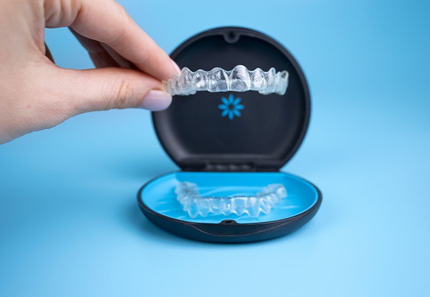 Patient placing clear aligner in case