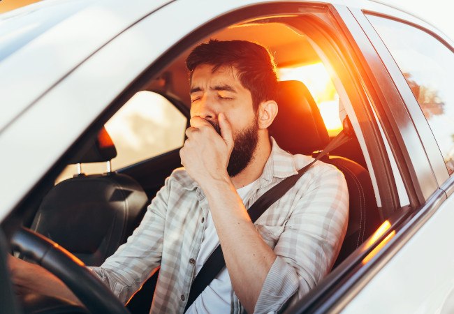 Sleepy man behind a steering wheel 