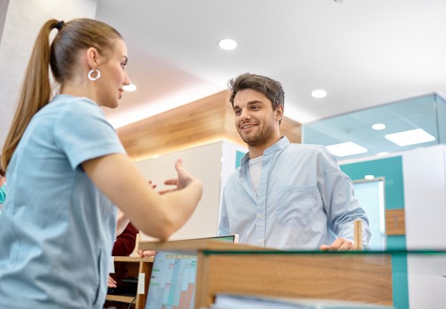 Man talking to front desk about sleep apnea treatment