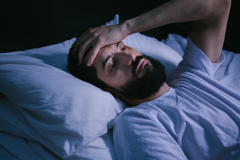 a man in bed and not looking well-rested