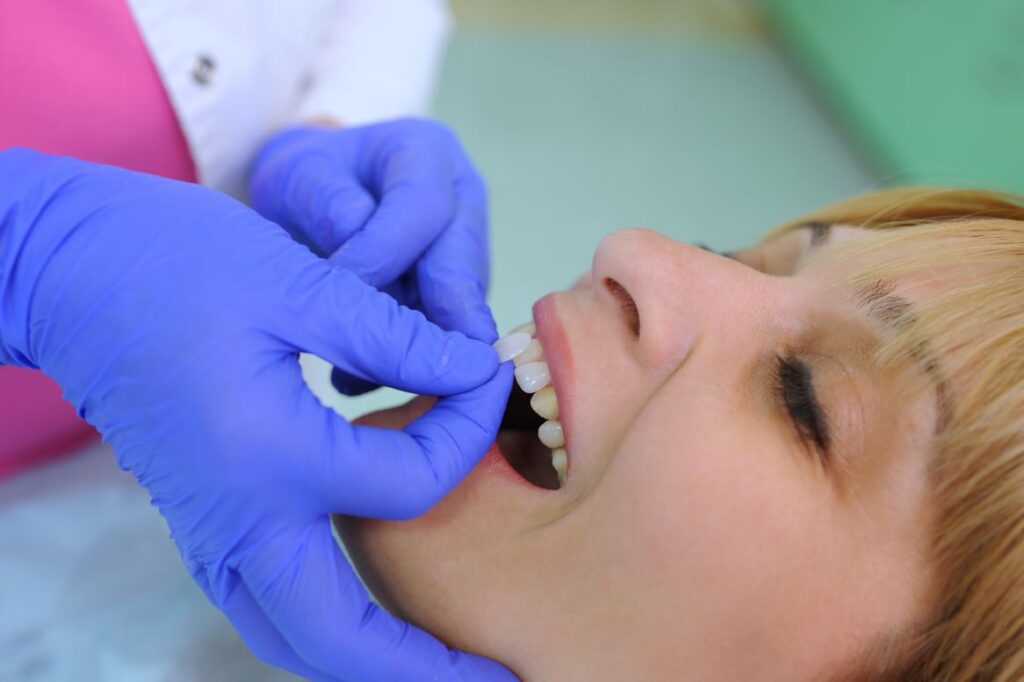 A woman getting veneers placed by her dentist.